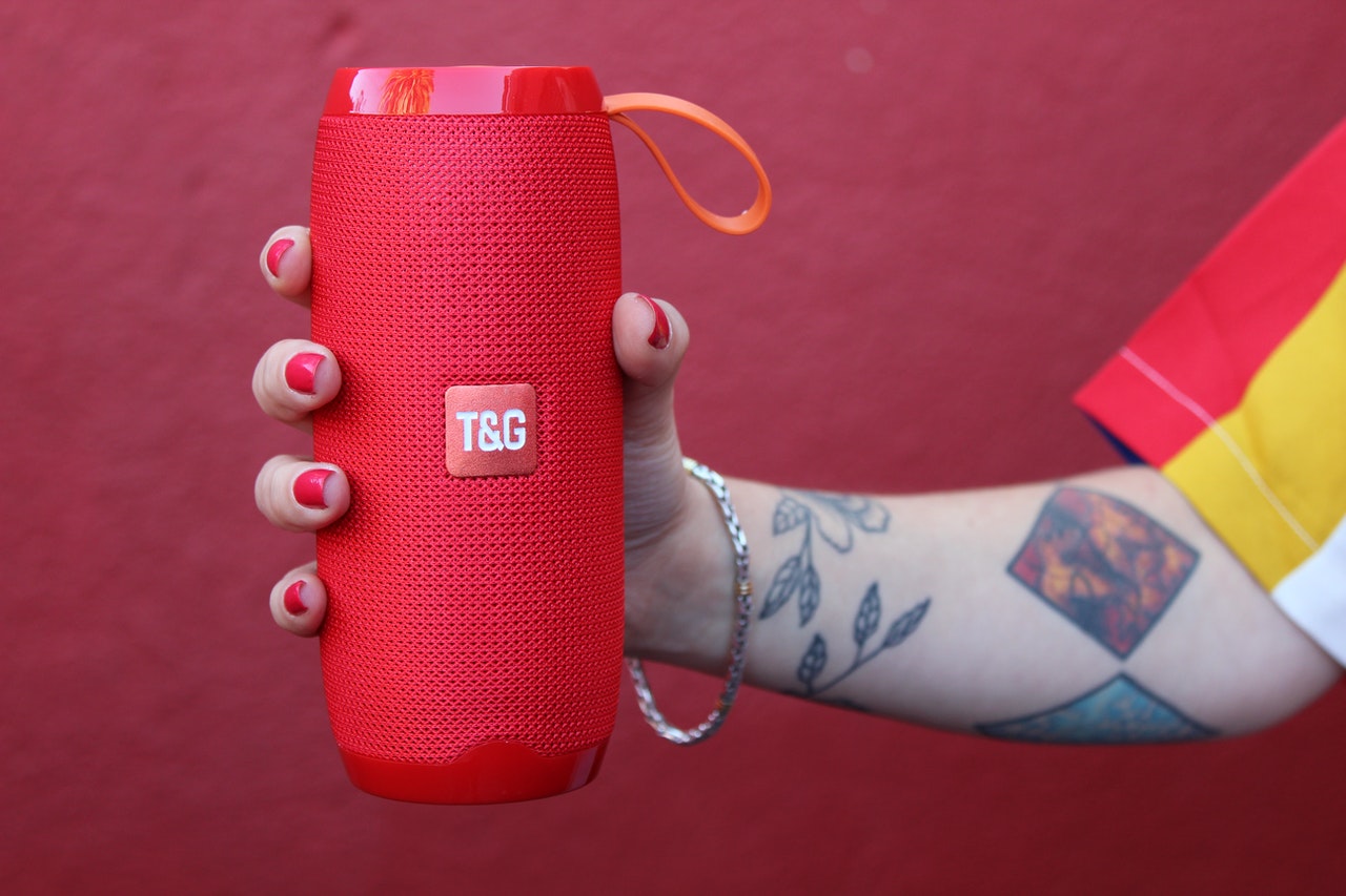 Red audio speaker in a woman's hand